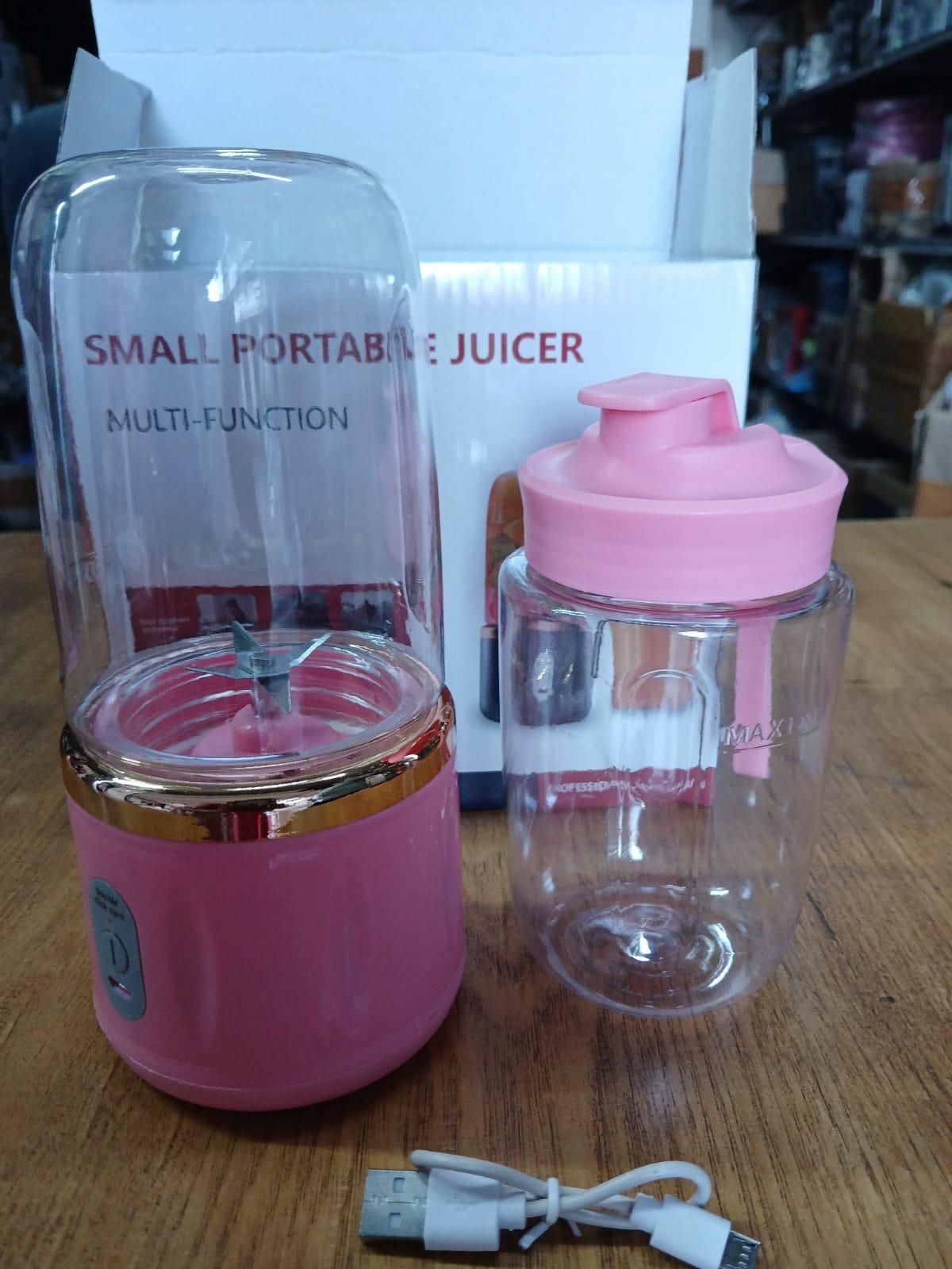 Best compact portable juicer in pink with USB charging cable and clear blending cup on wooden table
