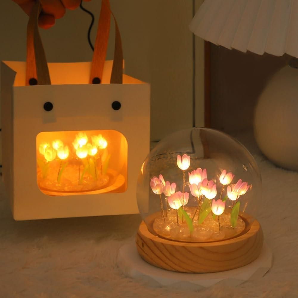 Decorative flower LED lamp with pink glowing flowers inside a clear dome on a wooden base