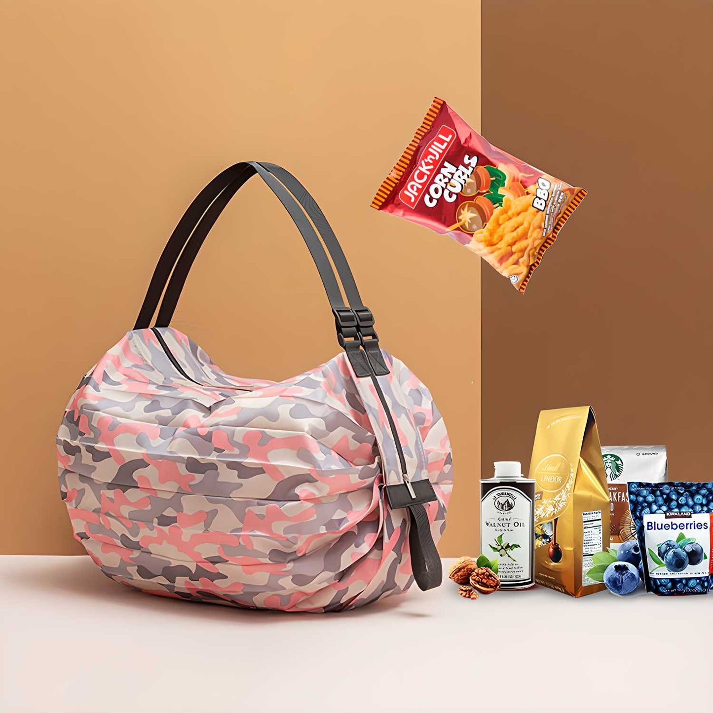 Pink camo foldable shopping bags set with black handles holding groceries including snacks coffee and blueberries