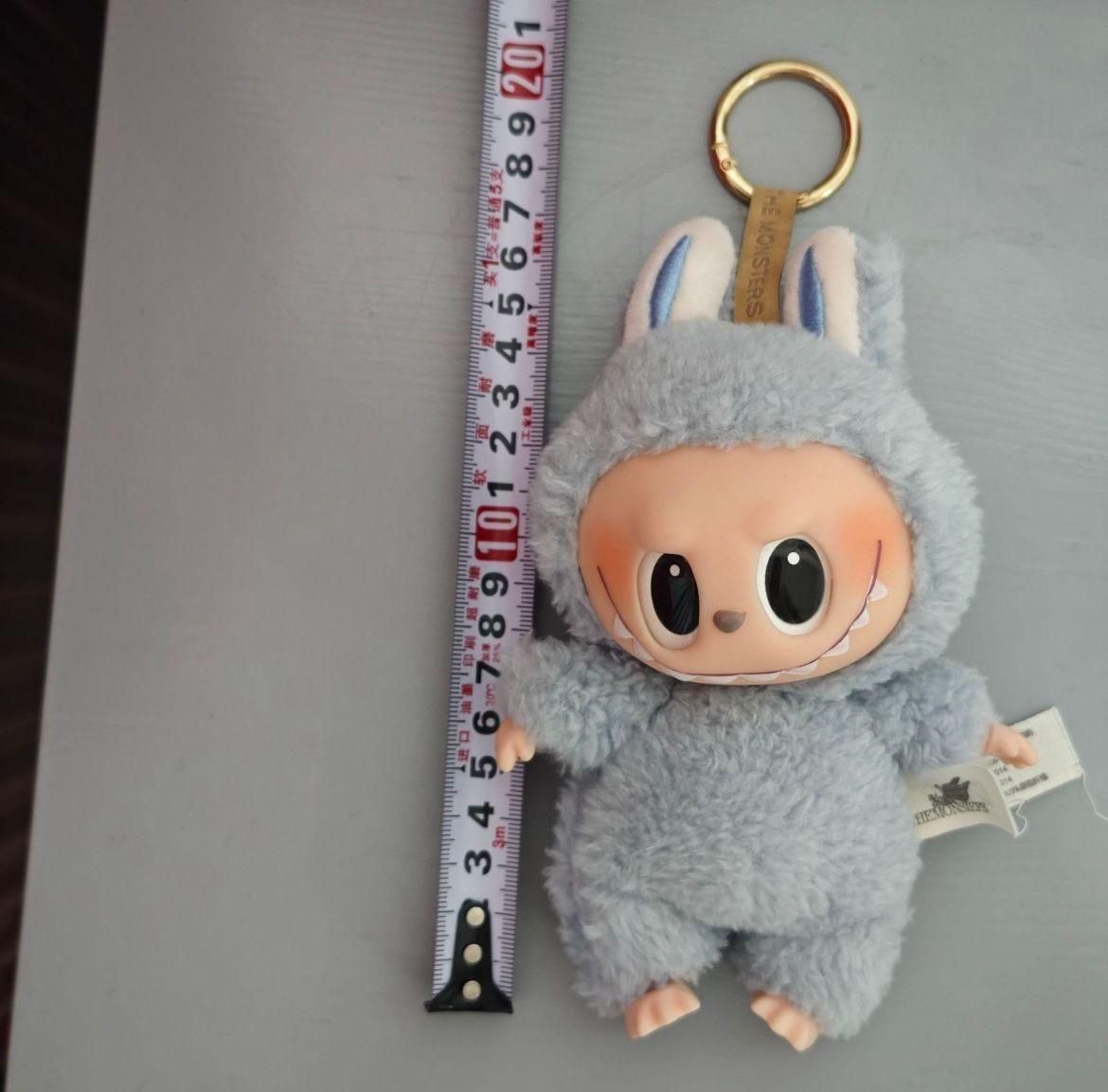 Labubu doll online India gray plush keychain with big eyes and bunny ears next to measuring tape