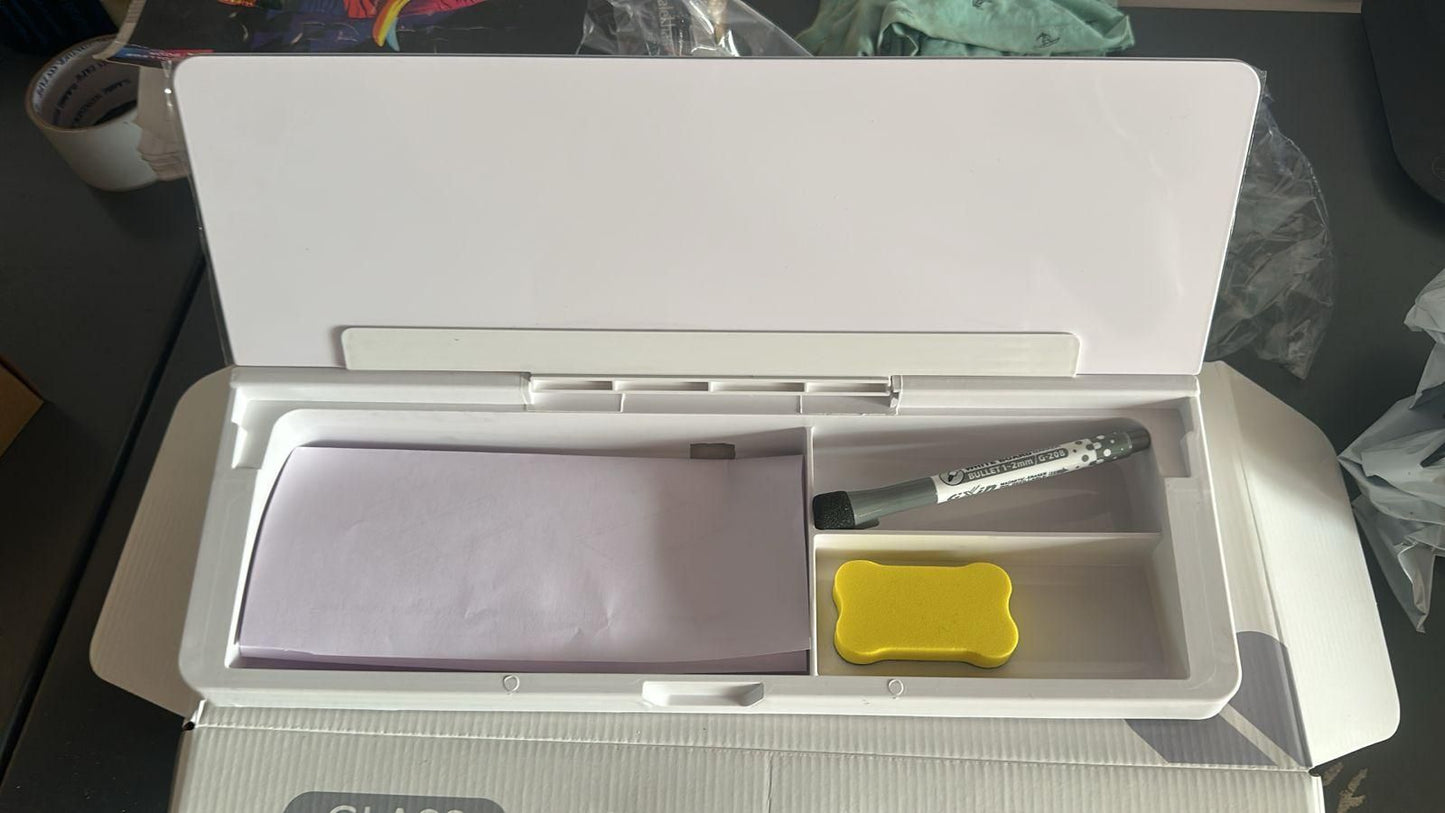 White multifunctional storage desk board with compartments holding papers, pen, and small yellow item for office organization