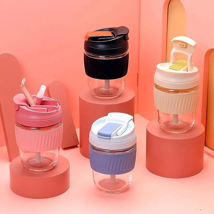 Set of colorful eco friendly glass tumbler India drinkware with silicone lids and straws on pink display