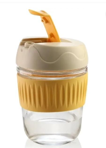 Eco friendly glass tumbler India with beige lid and yellow silicone grip for easy drinking