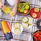 Best compact portable juicer blending fresh orange juice on picnic blanket with fruits and sandwiches