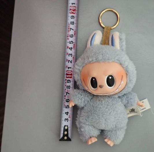 Labubu doll online India gray plush keychain with big eyes and bunny ears next to measuring tape