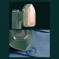 Compact portable clothes steamer with green body and copper steam plate removing wrinkles from blue shirt