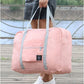 Pink portable travel organizer India with gray straps held by person in white shoes outdoors