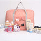Pink portable travel organizer India with gray handles surrounded by baby care items and clothes