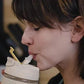 Woman drinking from an eco friendly glass tumbler India with a reusable straw and secure lid