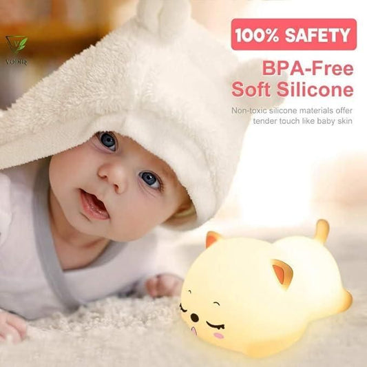 Cute silicone animal night lamp glowing softly next to baby wrapped in white hooded towel